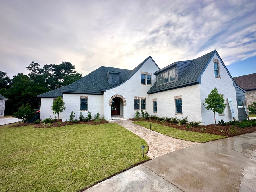 New construction home with fresh sod, foundation plantings and a paver walkway