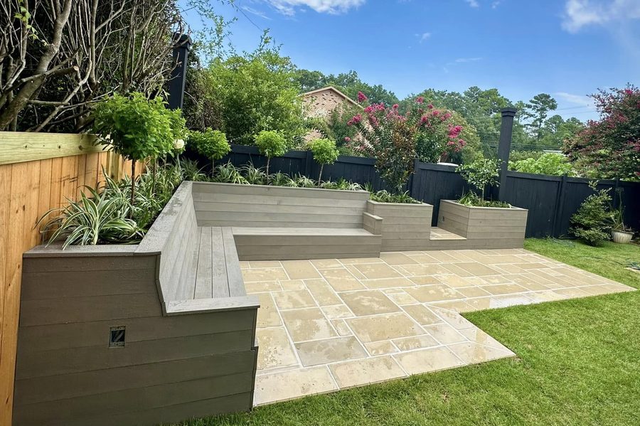 Travertine paver patio with built-in bench seating and raised planters